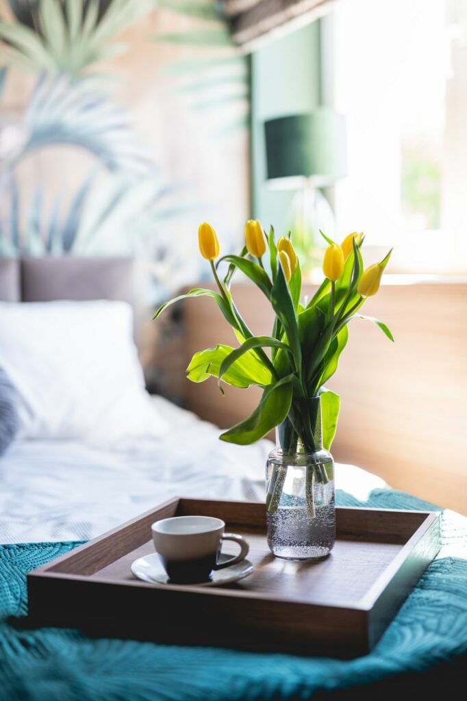 Coffee and flowers on bed tray in elegant bedroom